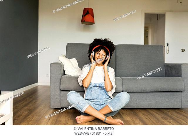 Happy woman sitting at home with headphones