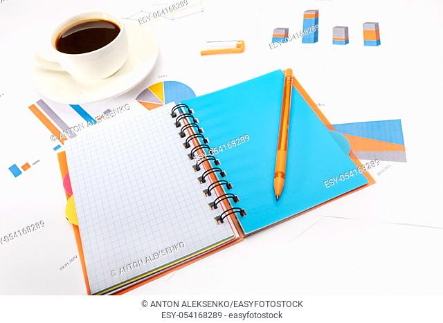Open notepad with a pen, cup of coffee and documents