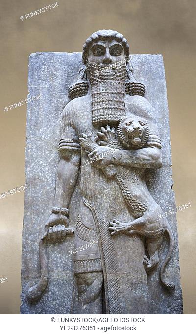 Stone relief sculptured panel of a Hero holding a lion. From the facade of the throne room, Inv AO 19862 from Dur Sharrukin the palace of Assyrian king Sargon...