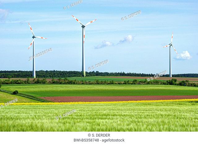 three wind wheels in field landscape in spring, Germany, Hesse