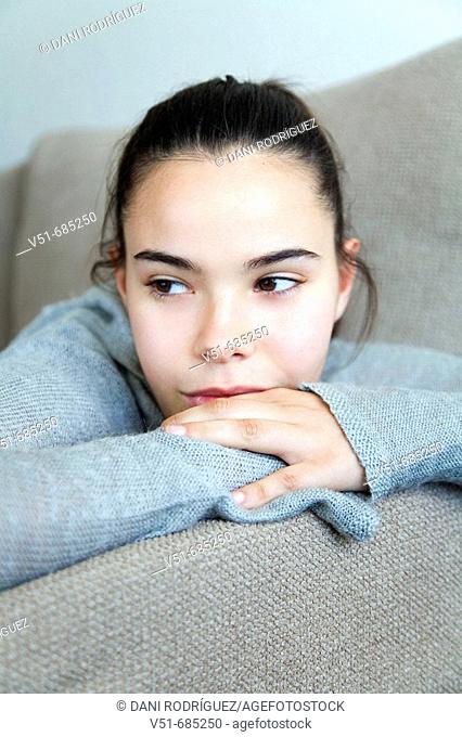 Teenage girl lying on the couch daydreaming