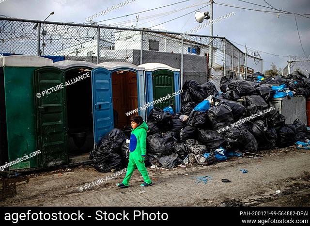 21 January 2020, Greece, Lesbos: A boy rings past garbage bags in the Moria refugee camp. The camps on the islands of Lesbos, Samos, Chios