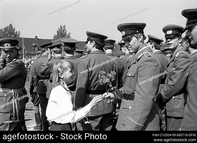 15 March 1982, Saxony, Delitzsch: Flowers from a young pioneer. Young soldiers of the NVA are sworn in on a sports field in Delitzsch in spring 1982