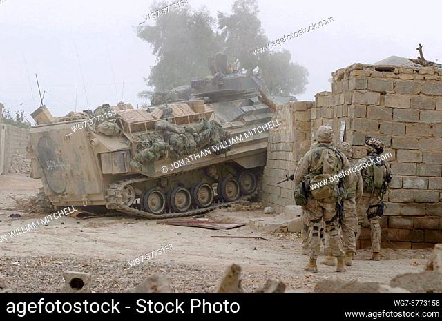 IRAQ Fallujah -- 17 Nov 2004 -- An Amphibious Assault Vehicle (AAV) drives through a wall and locked gate to open a path for US Marines assigned to 2nd Platoon