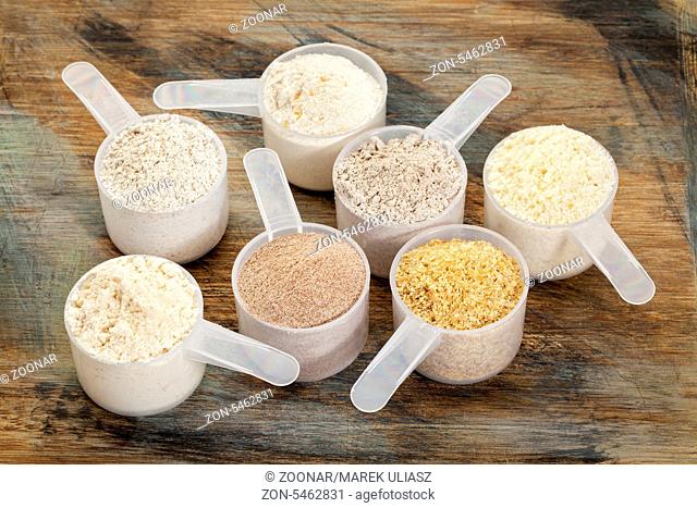 measuring scoops of gluten free flours - almond, coconut, teff, flaxseed meal, whole rice, brown rice, buckwheat