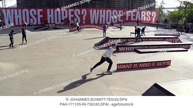 Skaters skate in a skatepark over ramps of a parcour adorned with edgy statements by American artist Barbara Kruger in New York, USA, 04 November 2017