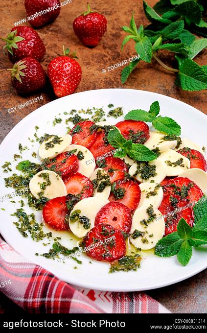 Light snack caprese with strawberries and mozzarella dressed  mint pesto