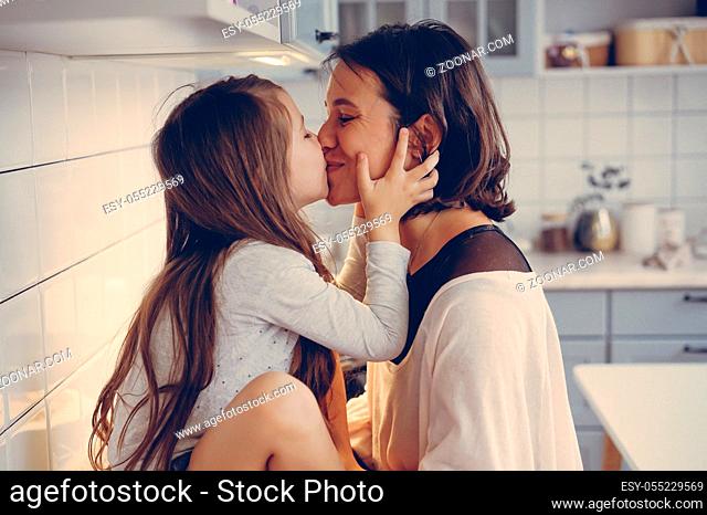 Mom and little daughter having fun together in the kitchen