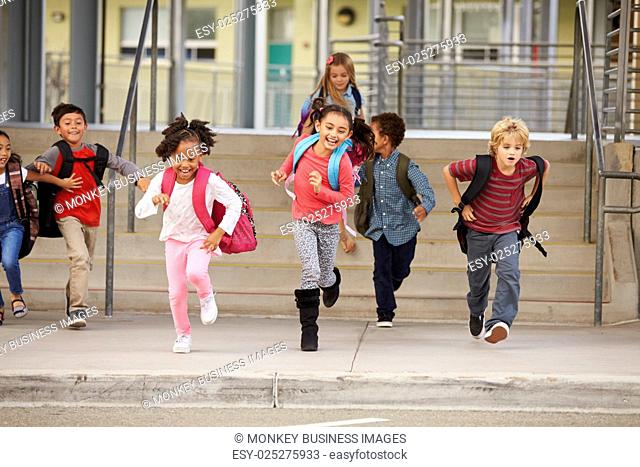 A group of elementary school kids rushing out of school