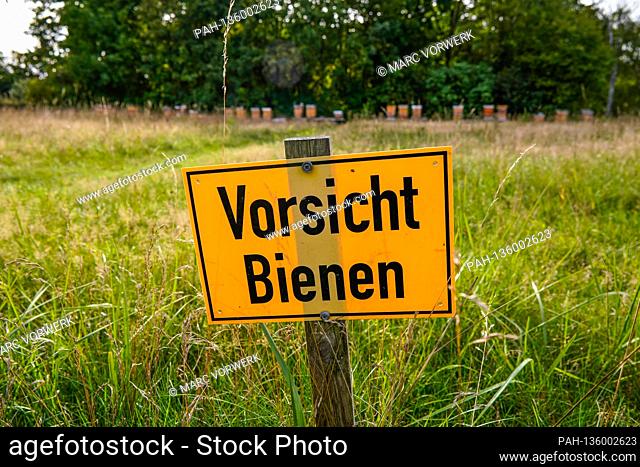 September 19, 2020, Berlin, a meadow with a yellow warning sign and the inscription: ""Be careful, bees"" on a wooden peg in the Blankenfelde-Pankow Botanical...