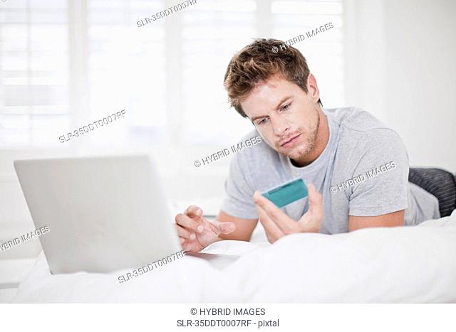 Man shopping online in bed
