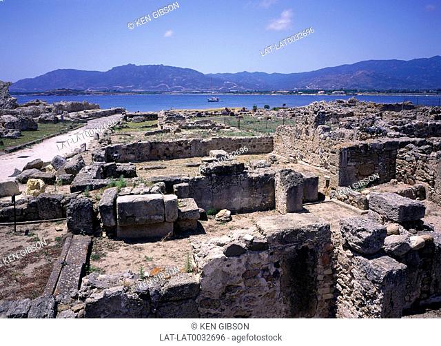 A Roman archaeological site of Nora on a headland with buildings walls and pathways