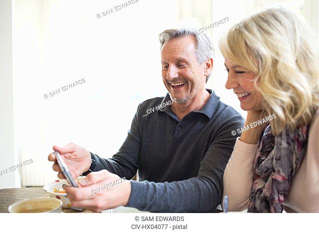 Smiling mature couple using smart phone