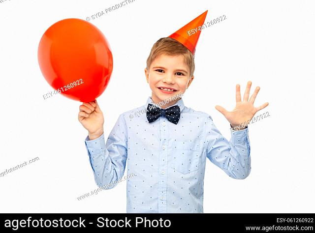 little boy in birthday party hat with blue balloon