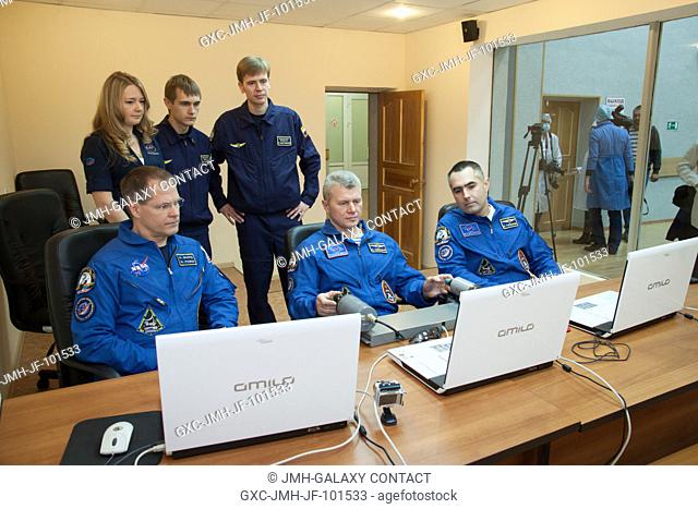 At the Cosmonaut Hotel crew quarters in Baikonur, Kazakhstan, Expedition 33 Soyuz Commander Oleg Novitskiy (center) practices docking techniques on a laptop...