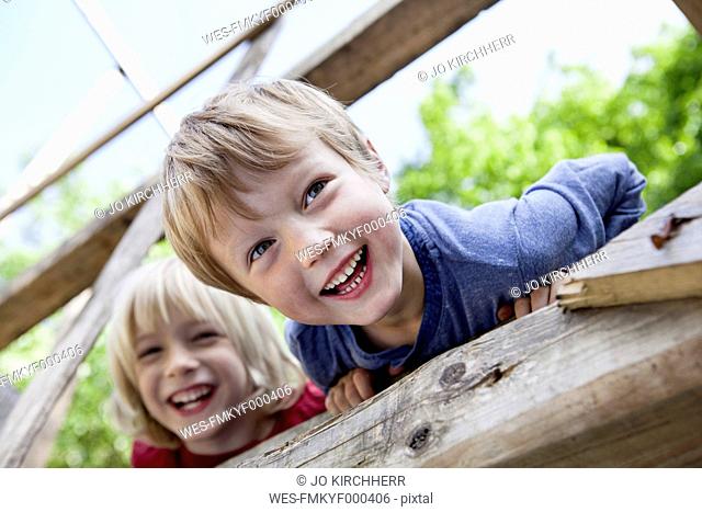 Germany, North Rhine Westphalia, Cologne, Boys playing in playground, smiling