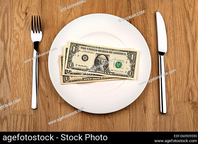 Image of plate with dollar bills and knife with fork
