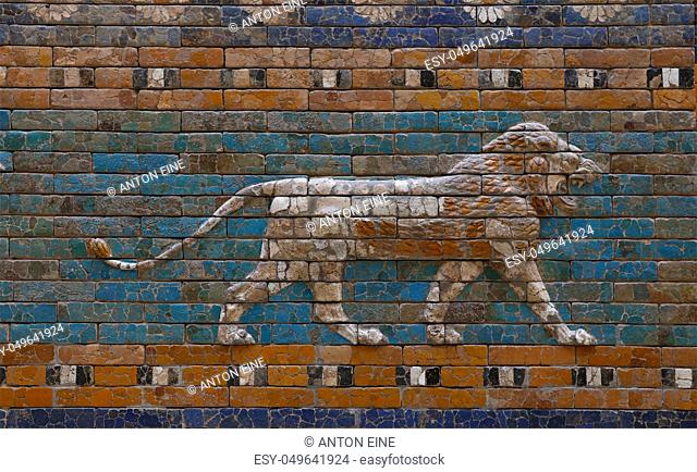 Close up beautiful glazed tiled bricks bas relief, decoration on ancient walls of Ishtar Gate of Babylon with images of Mesopotamian lions symbolizing the...
