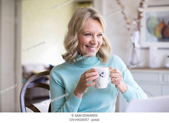 Smiling mature woman drinking coffee