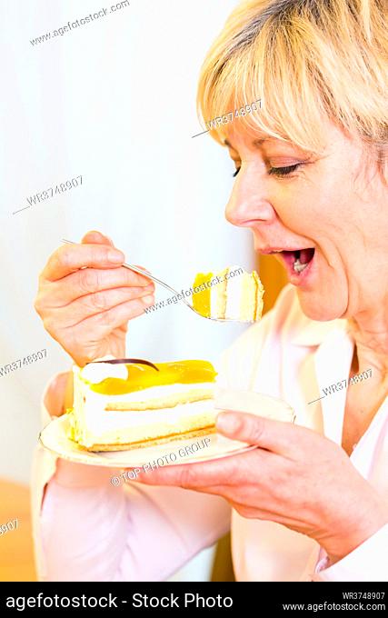 Old woman eating cake in the afternoon