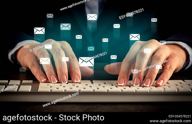 Business woman typing on keyboard with mail icons around