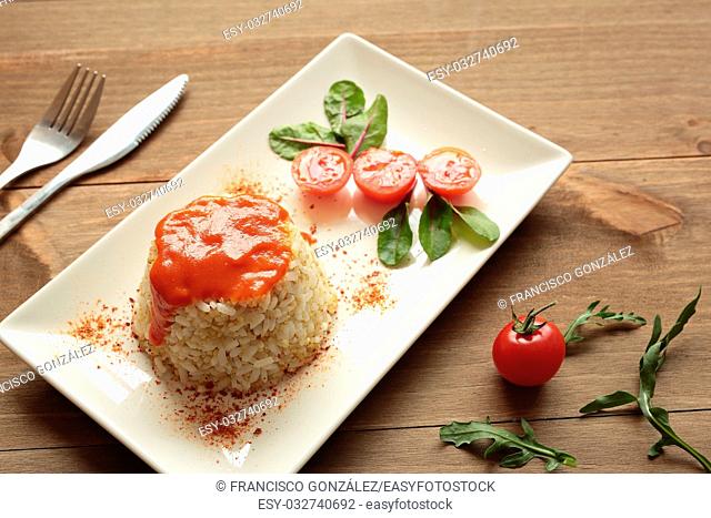 Cuban style rice decorated with cherrys tomatoes and a green leaves