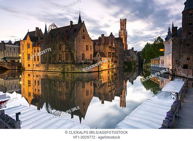 The medieval Belfry and historic buildings reflected in Rozenhoedkaai canal at dusk, Bruges, flemish region, West Flanders, Belgium, Europe