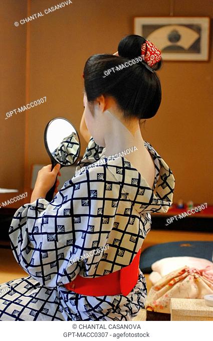A MAIKO’S APPRENTICE GEISHA TRADITIONAL MAKEUP AND HAIRDO. CHIGNON IN THE FORM OF A PEACH WARESHINOBU AND ADORNED WITH SILK RIBBONS KANOKO, GION DISTRICT, KYOTO