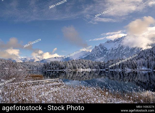 The Lautersee above Mittenwald in the fresh snow of a beautiful winter day with footbridge, in the background the Western Karwendel