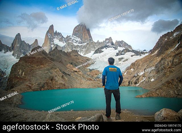 Hiker standing at base of mountain looking up