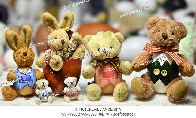 24 March 2019, Saxony, Leipzig: Cuddly hare eggs and teddies in duck, chicken, emu and dwarf chicken eggs (r-l) and budgie eggs (front) sit in the workshop of...