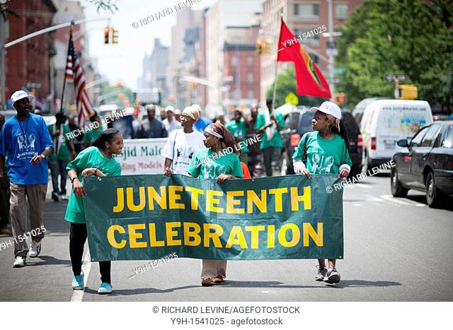 Participants march in the Juneteenth celebration parade, sponsored by the Masjid Malcolm Shabazz, through the streets of Harlem in New York Juneteenth