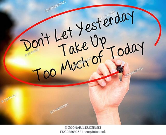 Man Hand writing Don't Let Yesterday Take Up Too Much of Today with black marker on visual screen