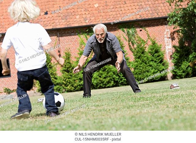 grandfather and child playing football