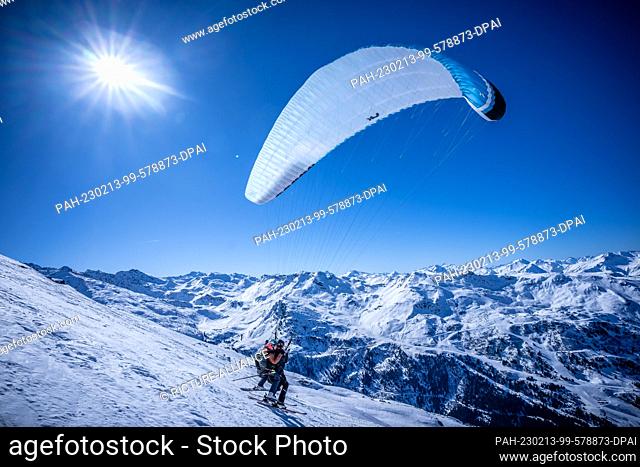 13 February 2023, France, Courchevel: A tourist takes off with a pilot for a tandem paragliding flight in the French Alps at the Courchevel-Meribel ski resort