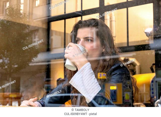 Young woman enjoying hot drink in cafe