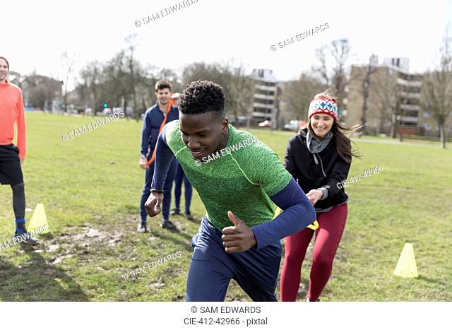 Man and woman exercising, doing team building exercise in park