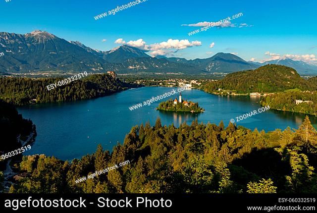 A picture of Lake Bled and the surrounding landscape, with the Lake Bled Island in the middle, as seen from a vantage point