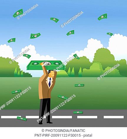 Businessman collecting money falling from the sky