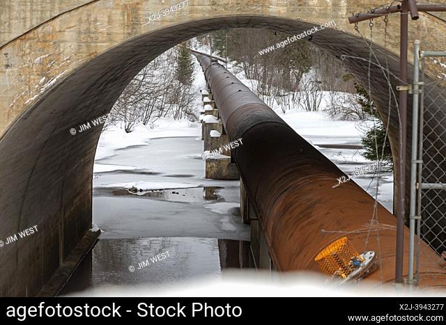 Au Train, Michigan - A hydroelectric power project operated by Renewable World Energies. A pipe carries water from the Forest Lake Dam to a power plant...