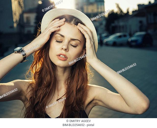 Pensive Caucasian woman with hand in hair