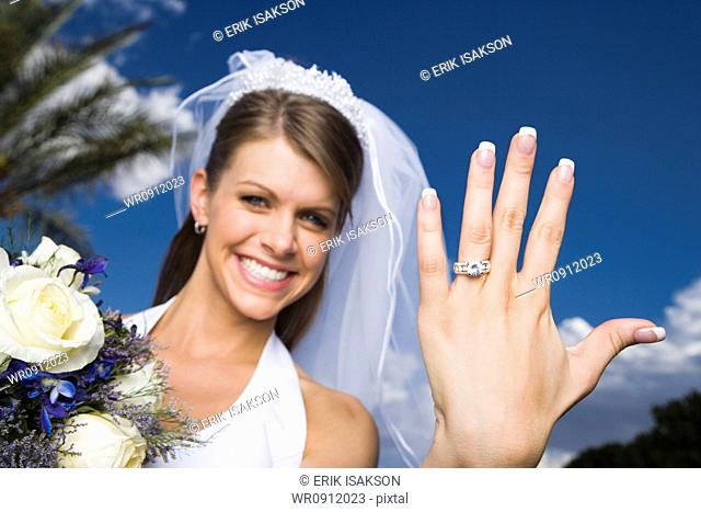 Portrait of a bride showing her wedding ring and smiling