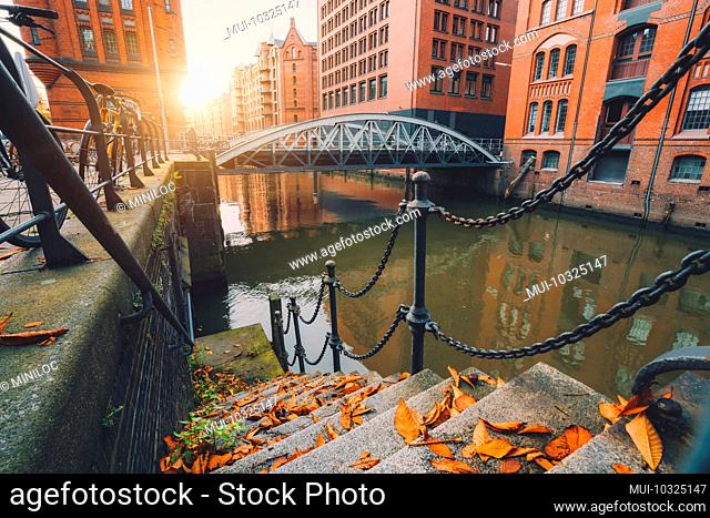 Speicherstadt, warehouse district in Hamburg, Germany, old brick buildings and canal in Hafencity on an autumn evening with sunset