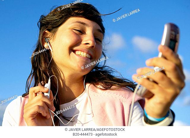 16 years old teenager listening to music in a MP3 mobile phone. Hendaye beach. Aquitaine. France