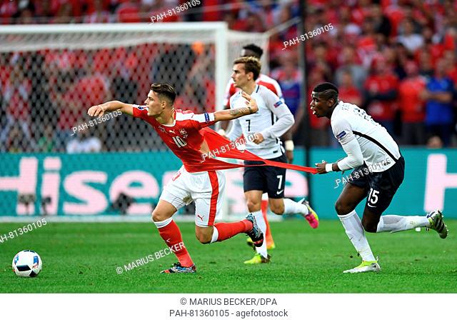 Paul Pogba (L) of France tries to hold Granit Xhaka of Switzerland and tears his football shirt during the preliminary round match between Switzerland and...