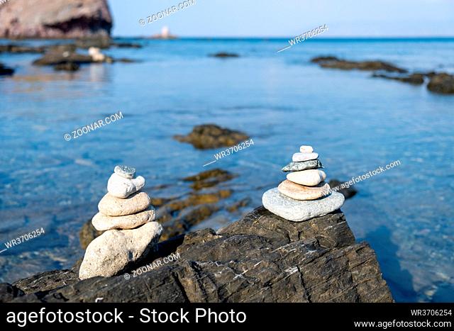 Pyramid of balancing white pebbles, on the rock of a rocky beach. Paphos Cyprus