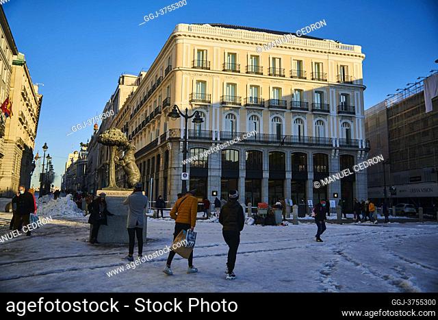 View of Puerta del Sol Square and Oso and Madrono Statue with people taking pictures and enjoying the snowy landscape on January 11, 2021 in Madrid, Spain