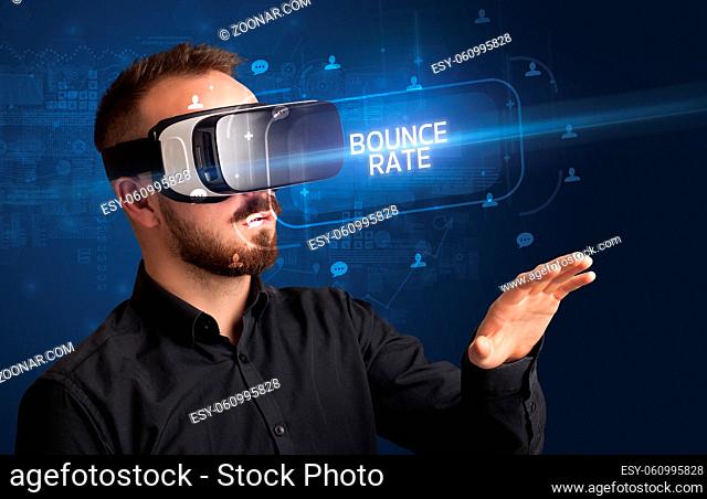 Businessman looking through Virtual Reality glasses with BOUNCE RATE inscription, social networking concept