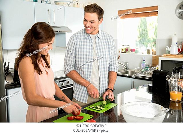 Couple cutting vegetables in kitchen