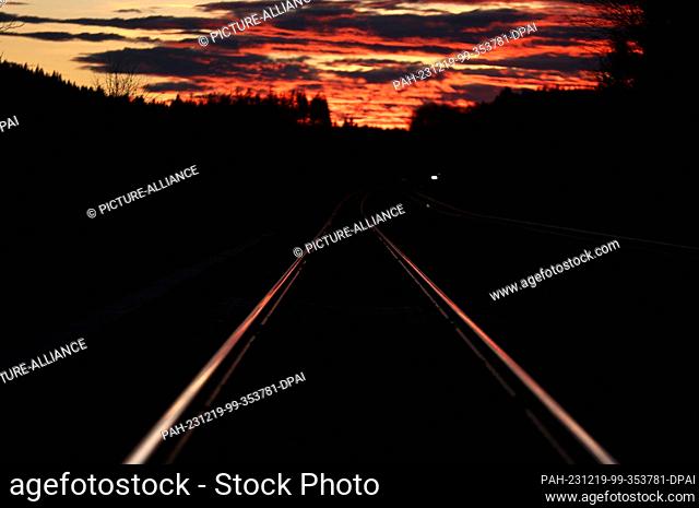 19 December 2023, Bavaria, Aitrang: Railroad tracks glow in the light of the setting sun. Photo: Karl-Josef Hildenbrand/dpa. - Aitrang/Bavaria/Germany